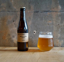 Load image into Gallery viewer, Bottle and glass of Goldings Biere de Saison from 'The Kernel' on a wooden surface with a concrete wall background