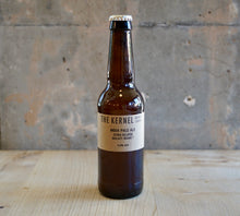 Load image into Gallery viewer, Beer bottle labeled 'The Kernel' on a wooden surface with a rustic background