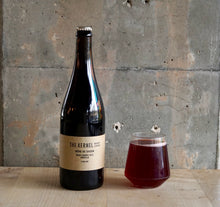 Load image into Gallery viewer, Bottle and glass of Biere de Saison Sour Cherry 2024 Morello labeled 'The Kernel' on a wooden surface with a concrete wall background.
